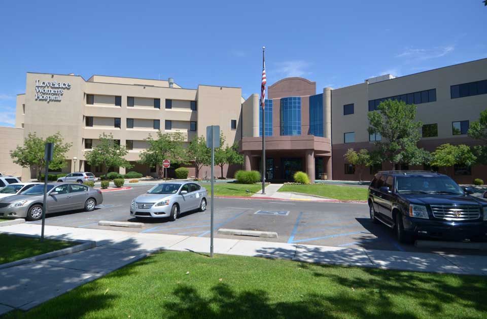 A large building with a lot of cars parked in front of it.