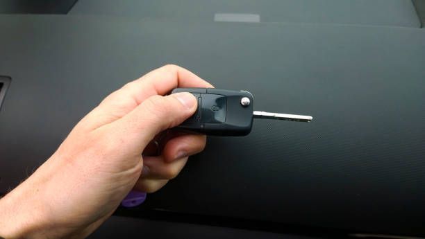 A person is holding a car key in their hand.