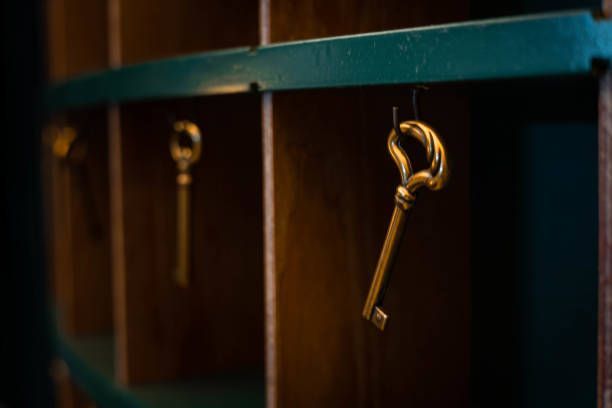 Three keys are hanging on a shelf in a dark room.