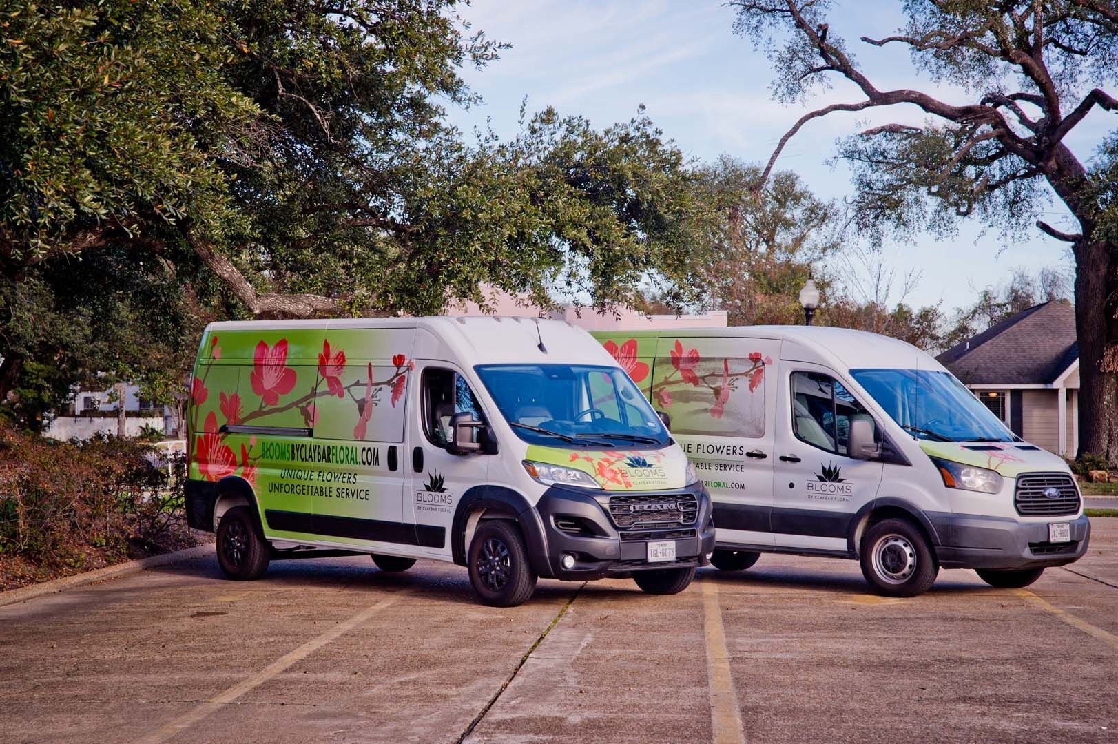 two vans are parked next to each other in a parking lot .