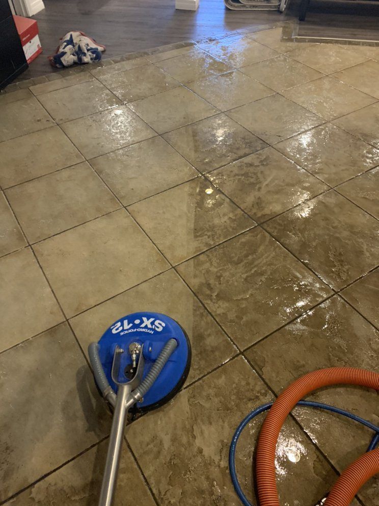 A tile floor is being cleaned with a vacuum cleaner.