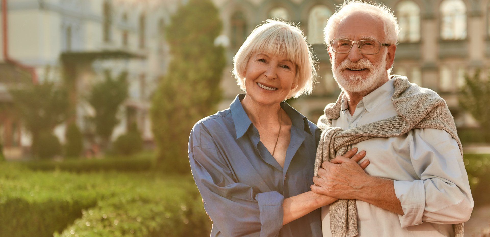 A man and a woman are standing next to each other in a park.