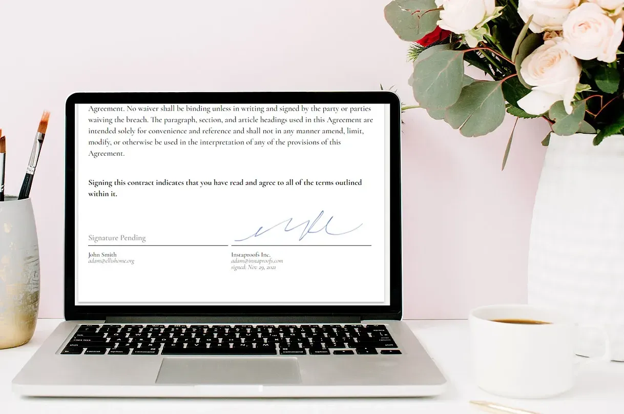 Laptop displaying text with signature, flowers, and a coffee cup.