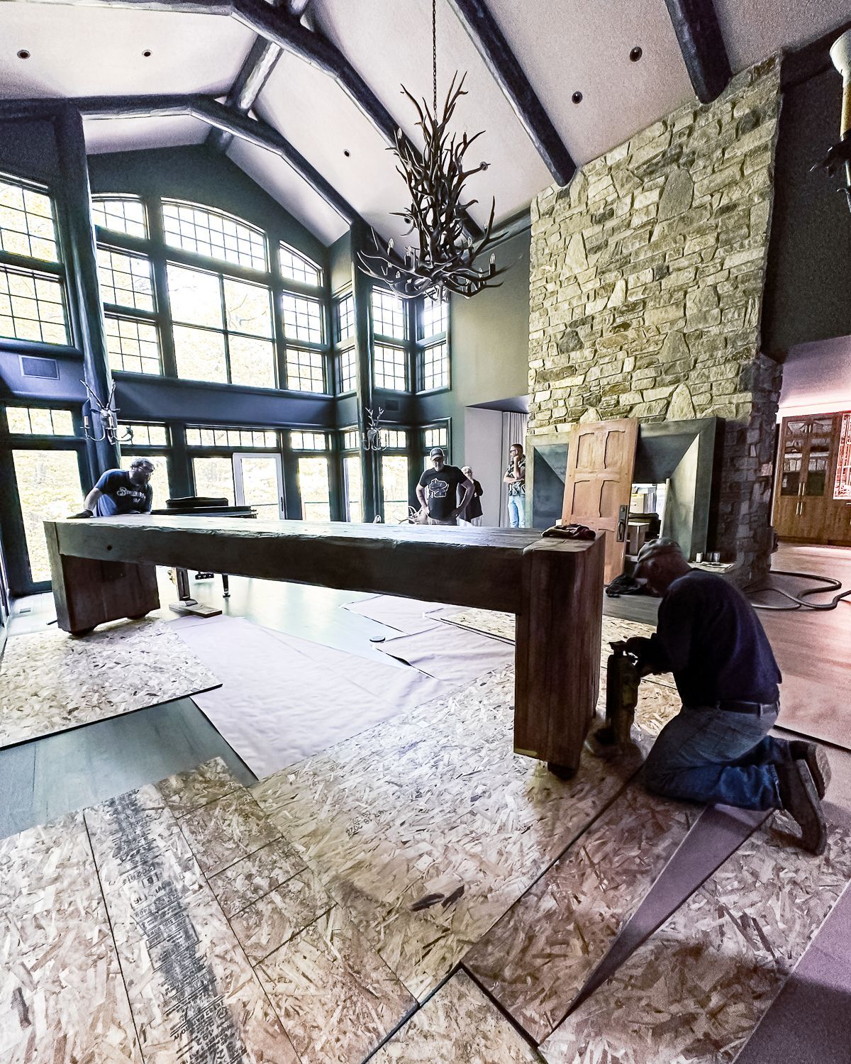 A man is kneeling in front of a 2500 pound table in a large room.