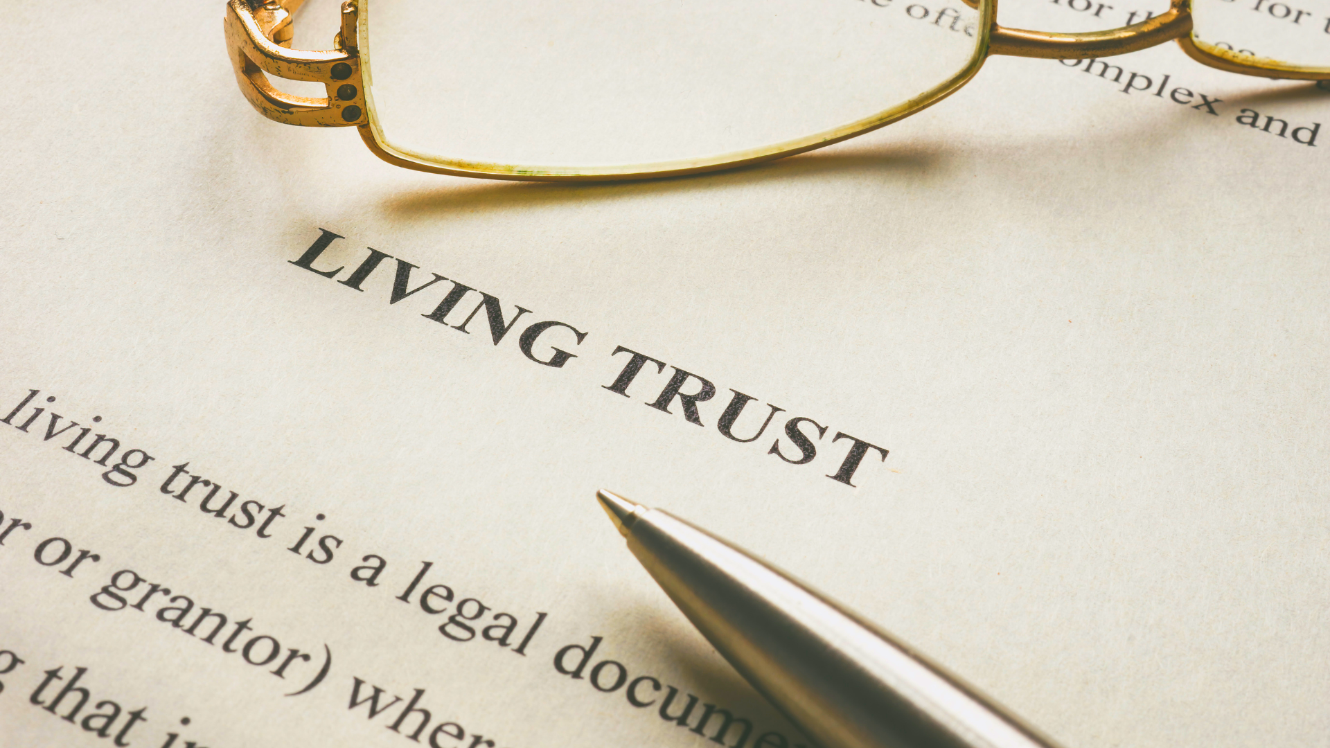 A pen is sitting on top of a living trust document