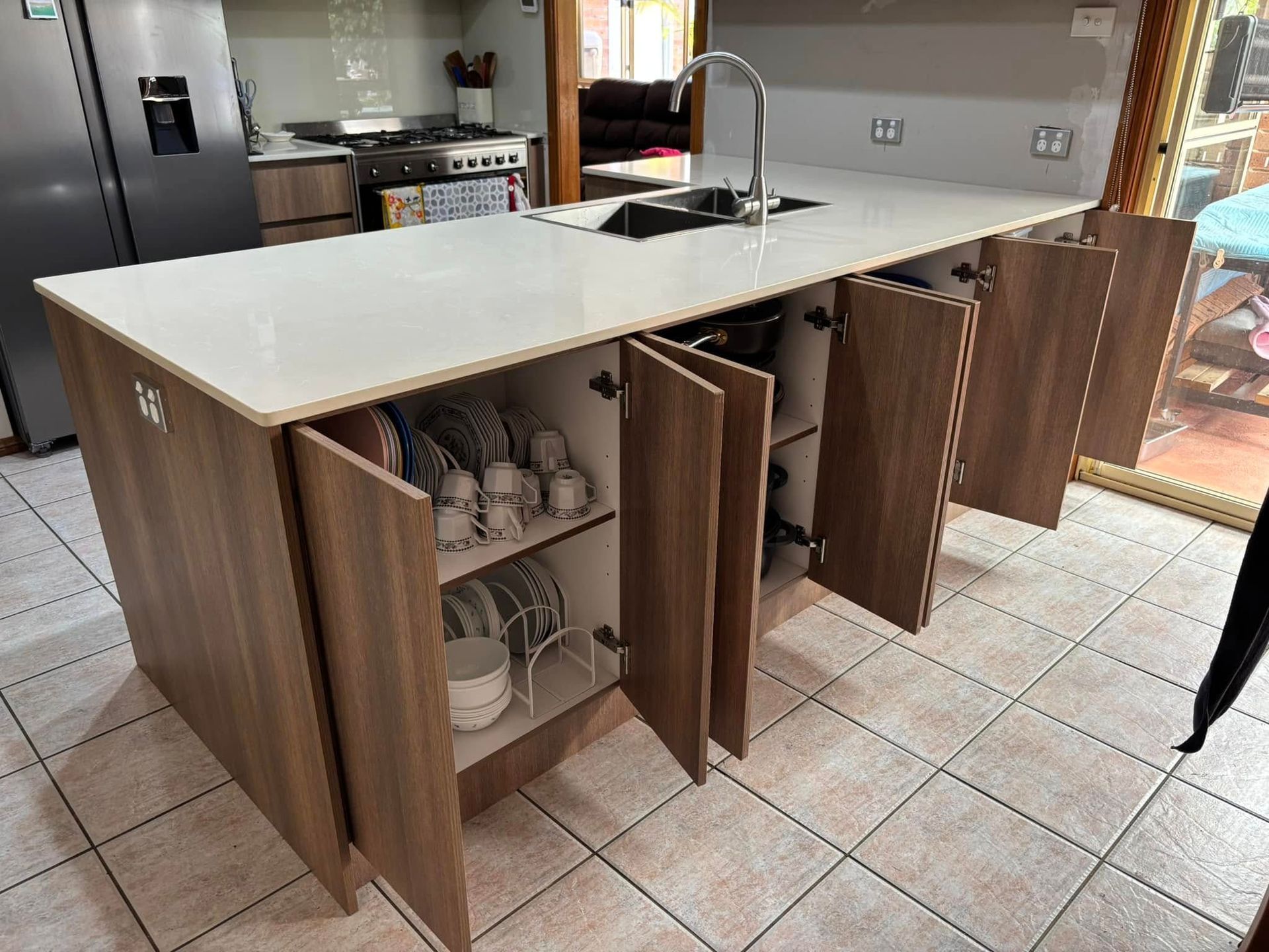 Kitchen Island With Open Cabinets, Brown Wood Finish, And White Countertop — Protech Renovations & Joinery in Southern Highlands, NSW