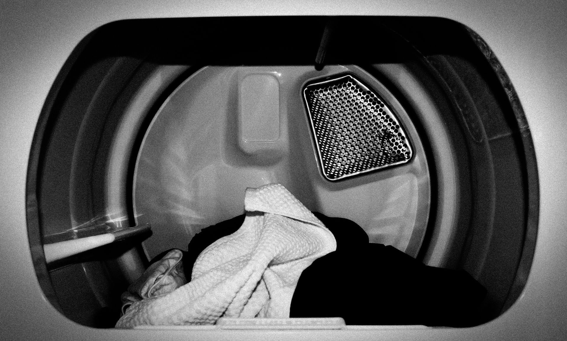Dryer needs servicing shown by laundry machine with warning lights and clothes inside