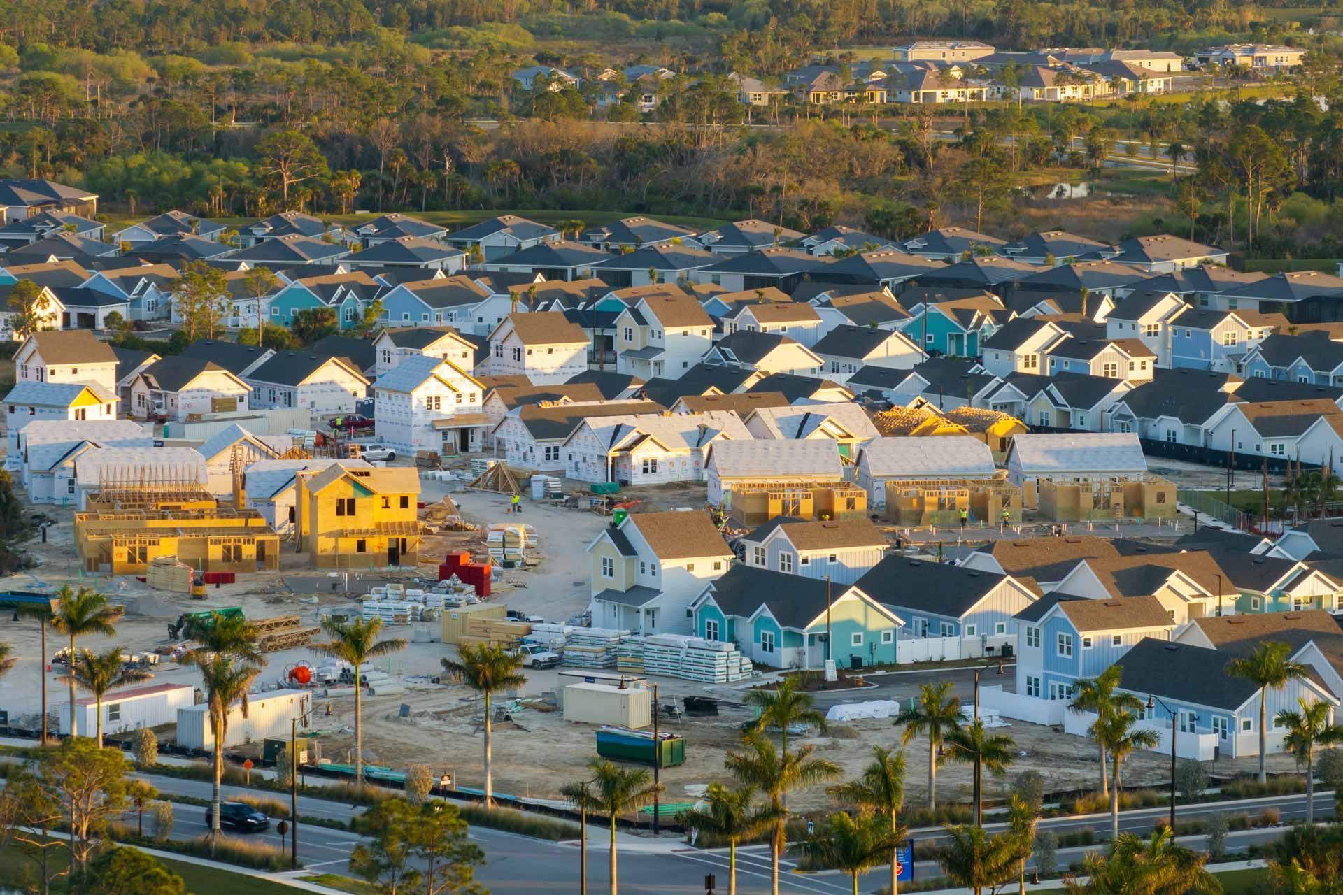 Aerial view of a suburban neighborhood with newly constructed houses in various pastel colors.