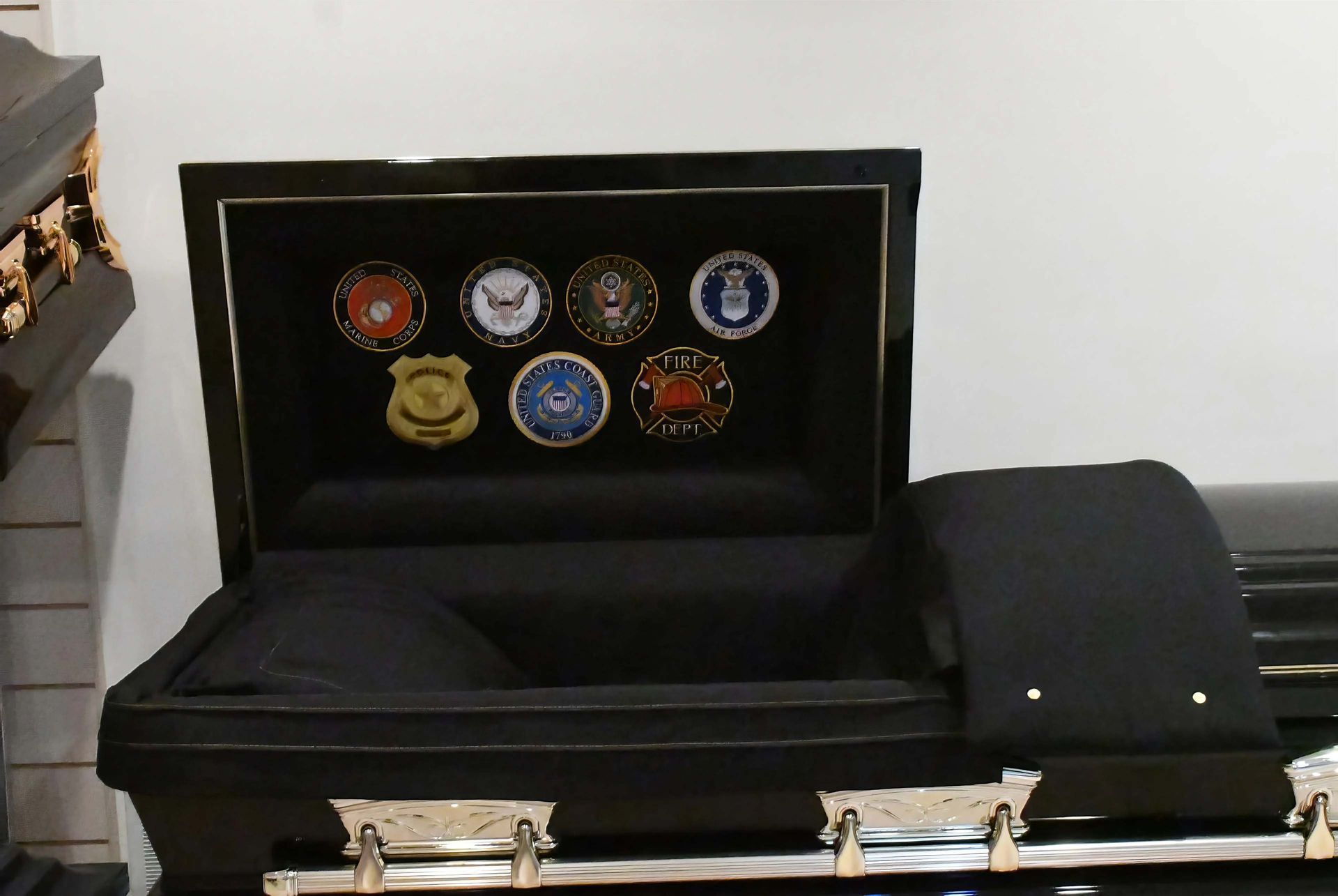 A black coffin with a display of coins in it