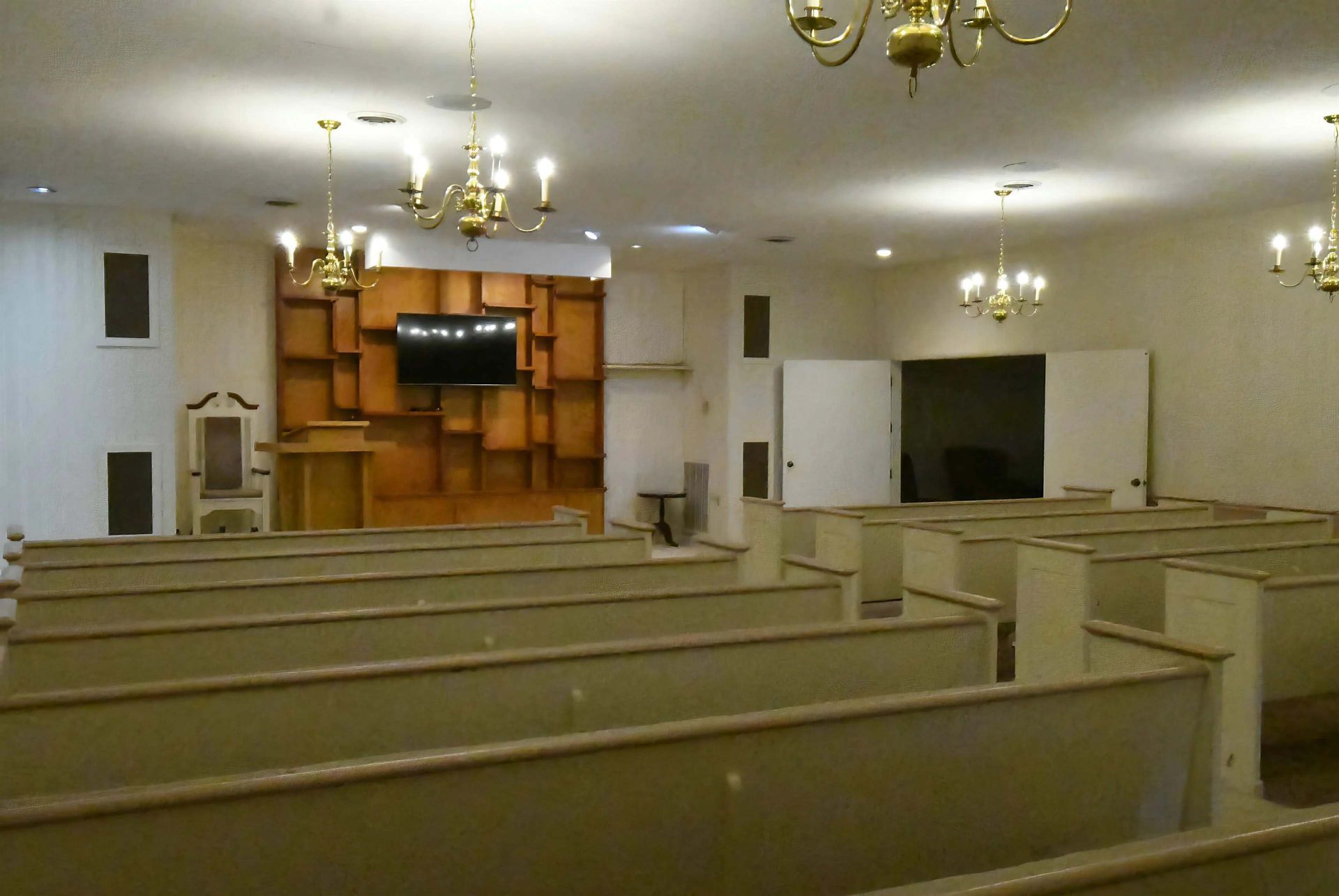 An empty church with rows of benches and a podium