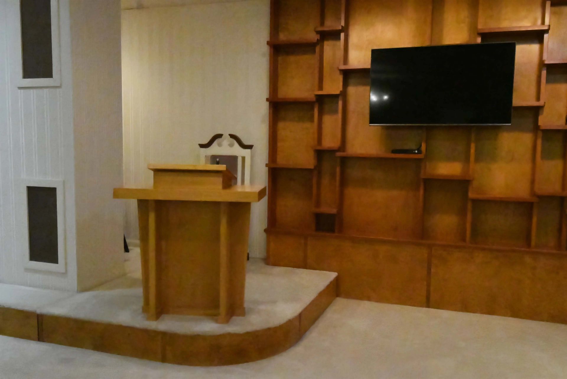 A room with a podium and a flat screen tv