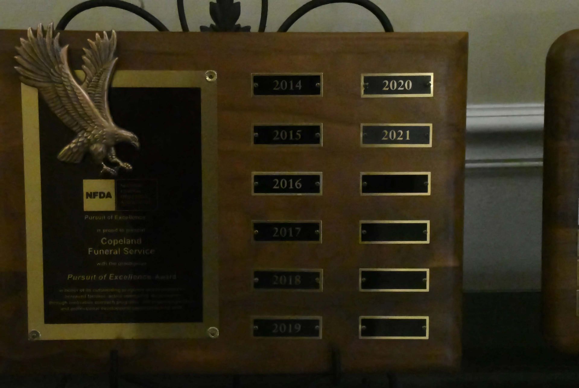 A wooden plaque with a picture of an eagle on it