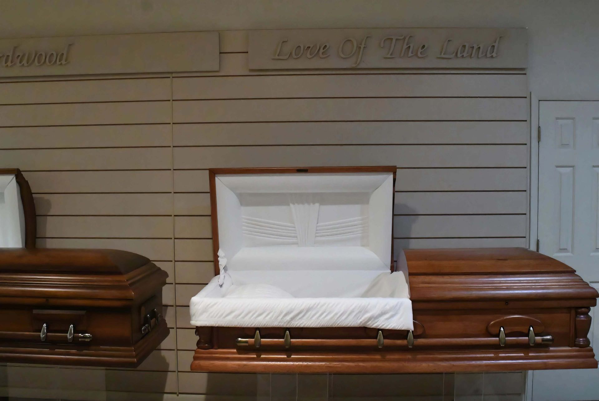 Two wooden coffins are sitting on a shelf in a room.