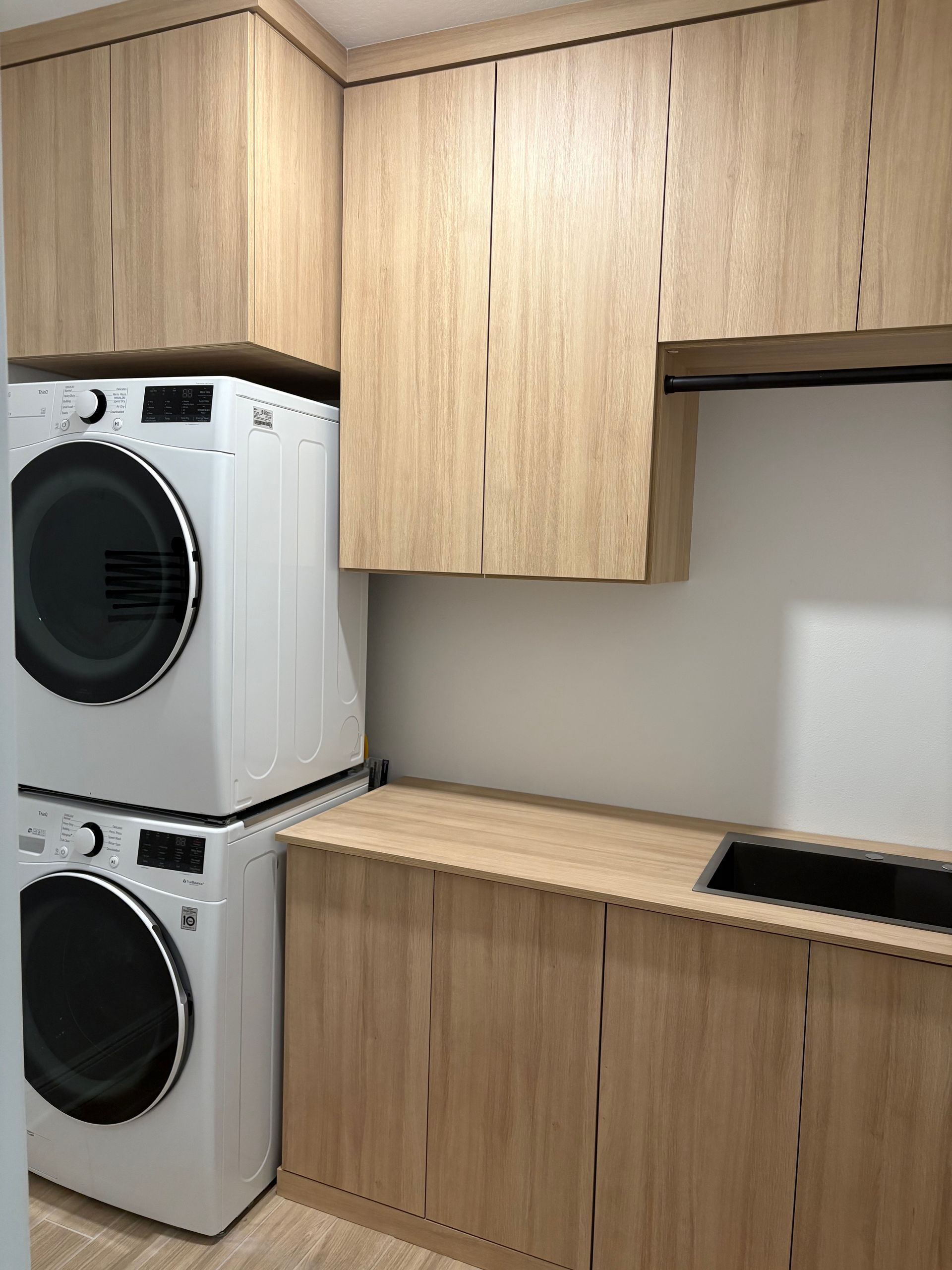 A laundry room with a washer and dryer stacked on top of each other.