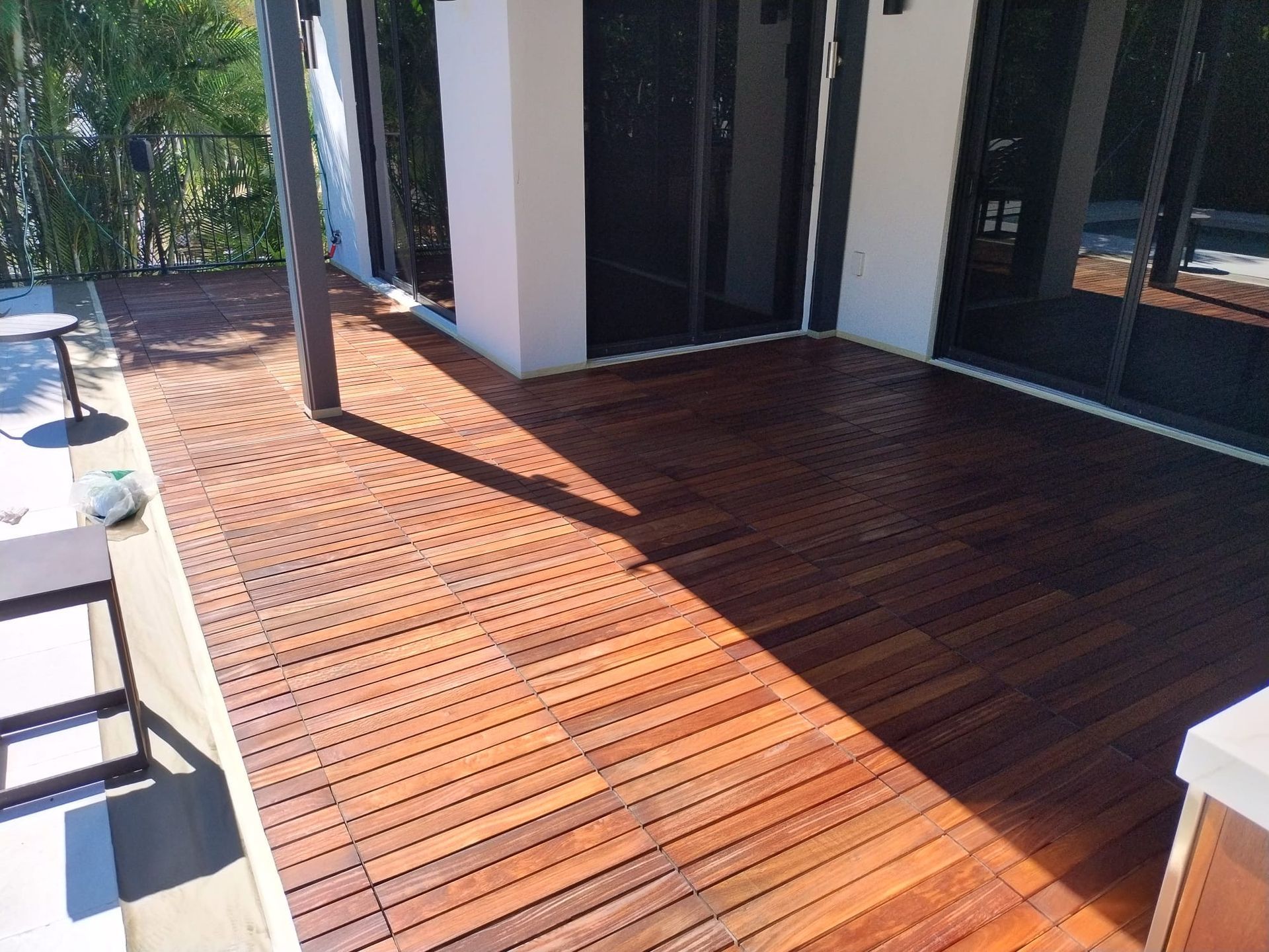 A wooden deck with a sliding glass door in the background