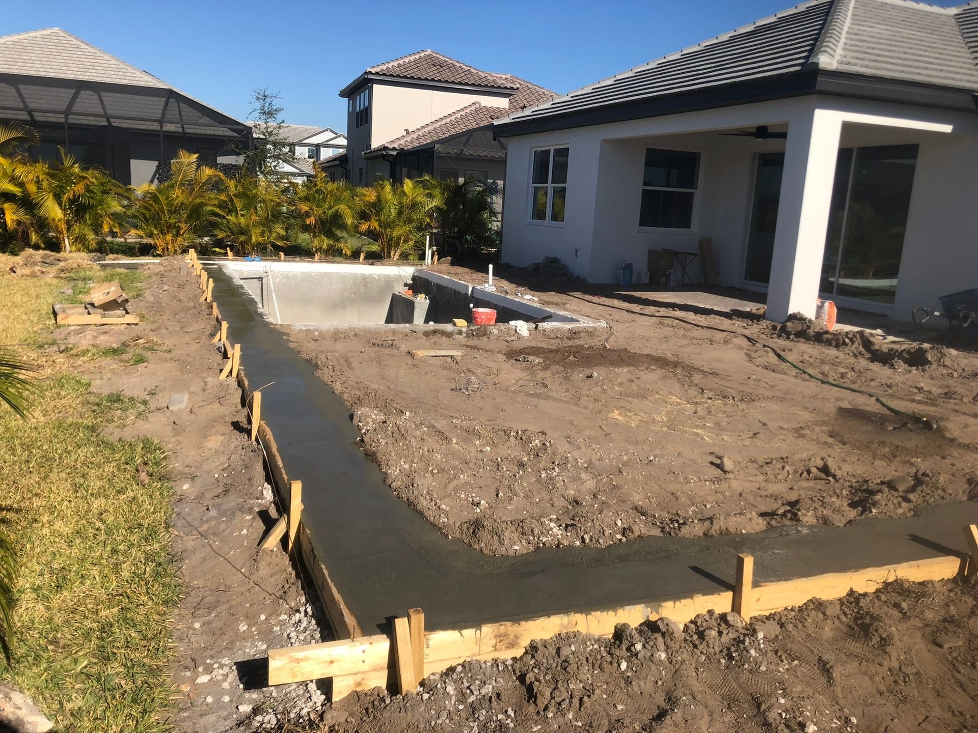 A house is being built next to a swimming pool.