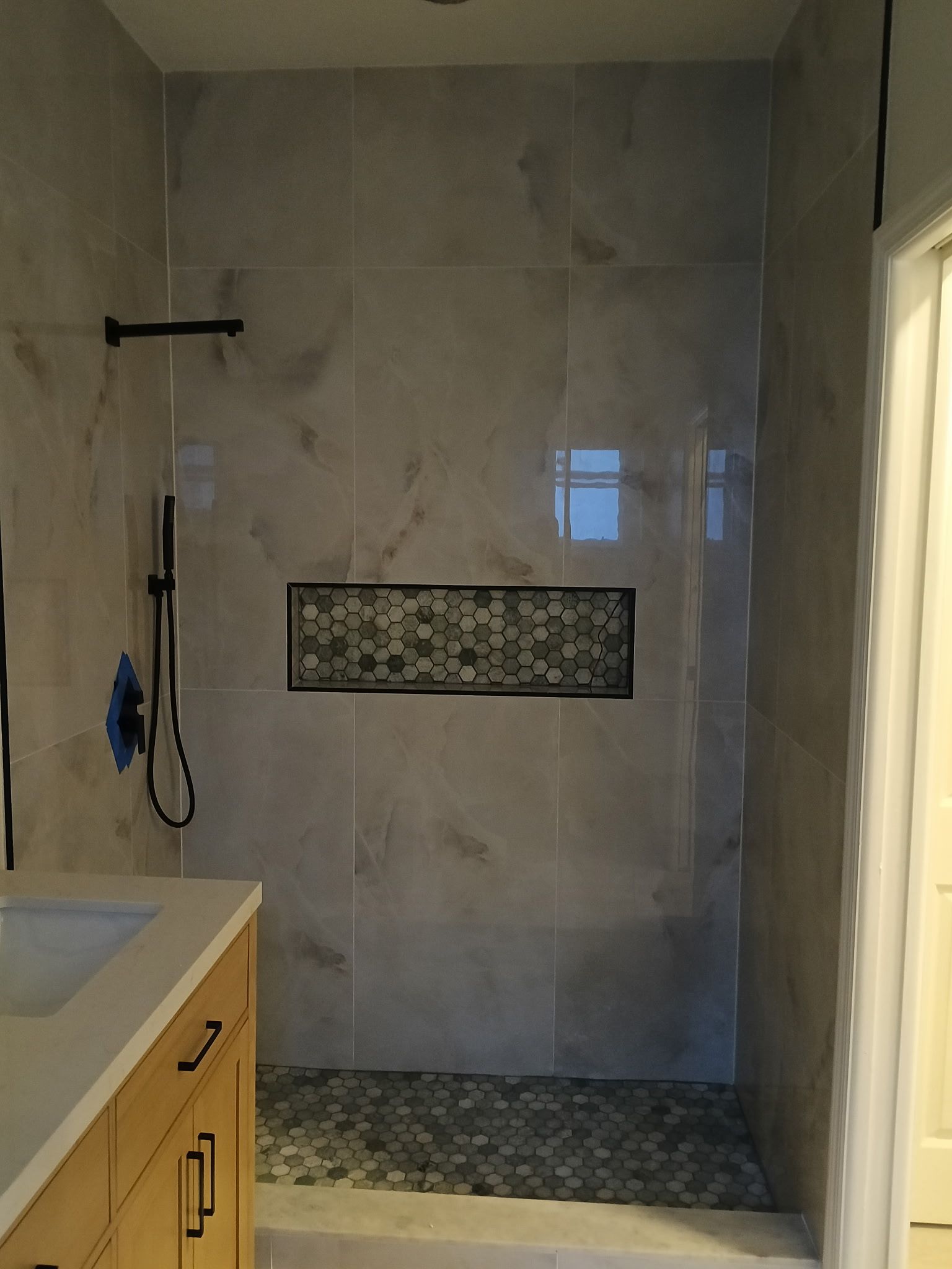 A remodeled bathroom with a walk-in shower. 