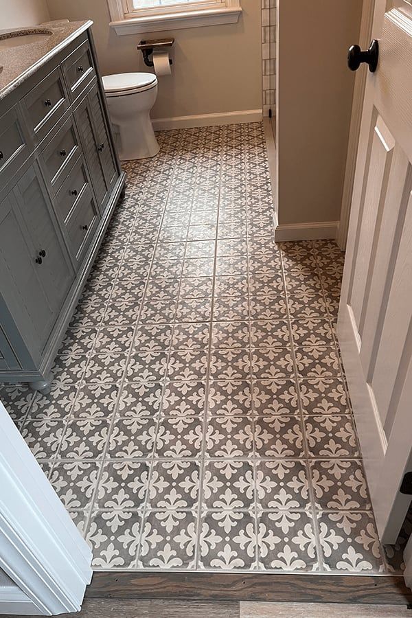 A bathroom with a tiled floor and a toilet.
