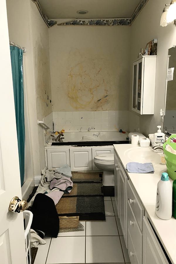 A bathroom with a tub , toilet , sink and mirror.