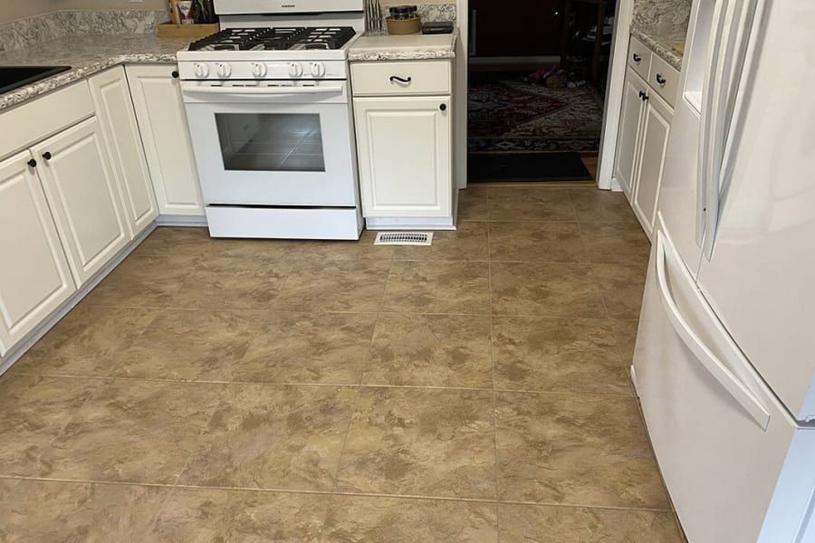 A kitchen with a stove , refrigerator , and sink.