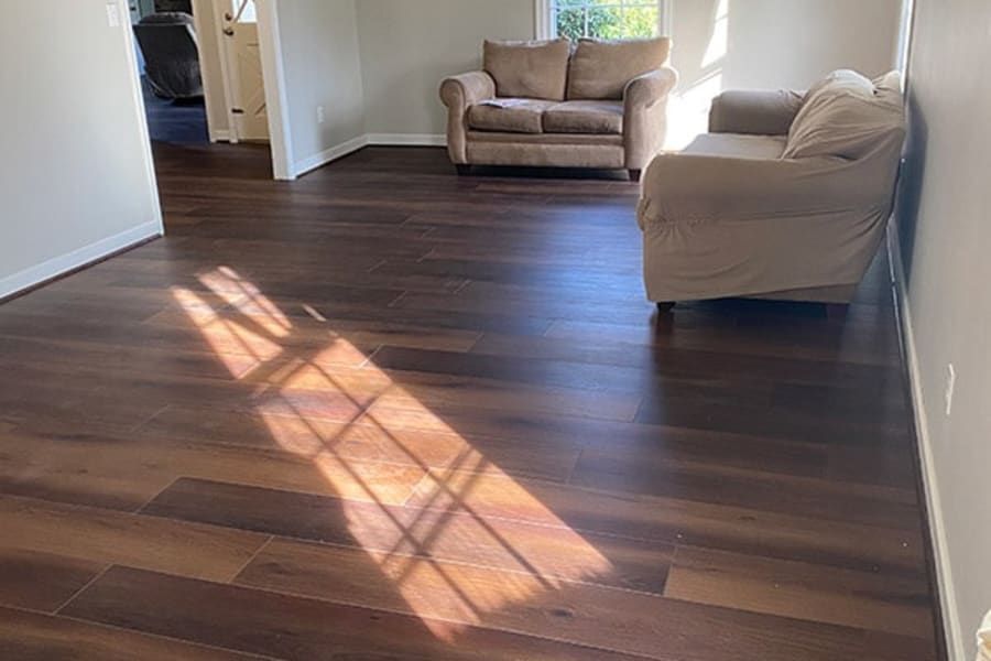 A living room with hardwood floors and a couch and chair.