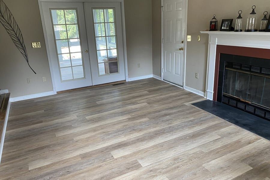 A living room with hardwood floors and a fireplace.