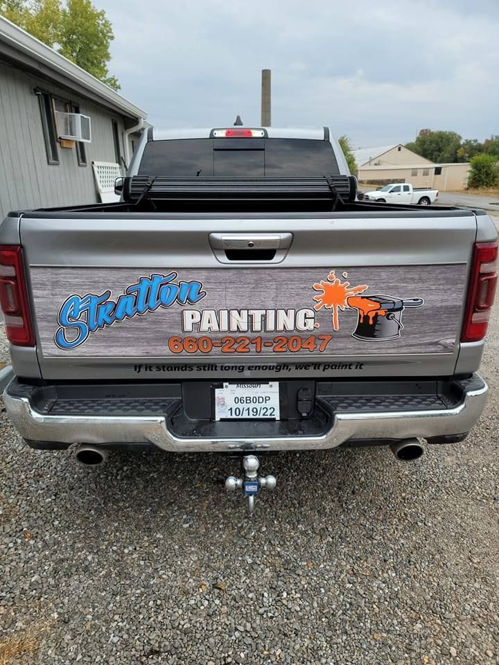 The back of a truck with a painting company advertisement on it.