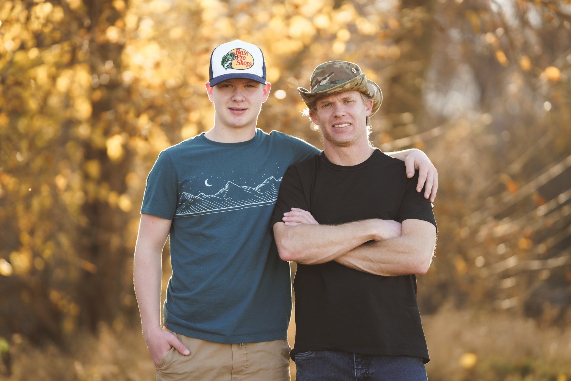Two men are standing next to each other with their arms crossed.