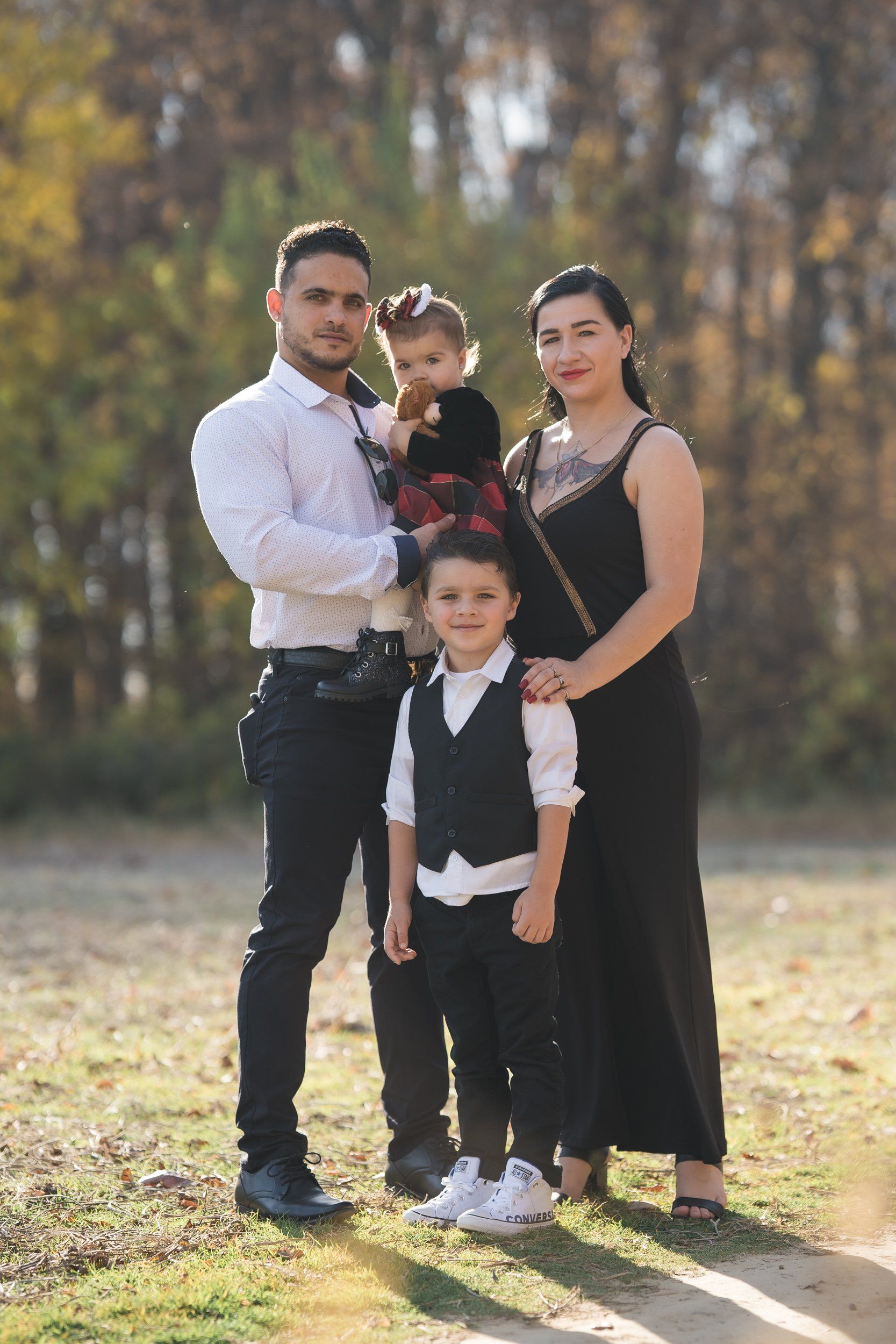 A family is posing for a picture in a park.