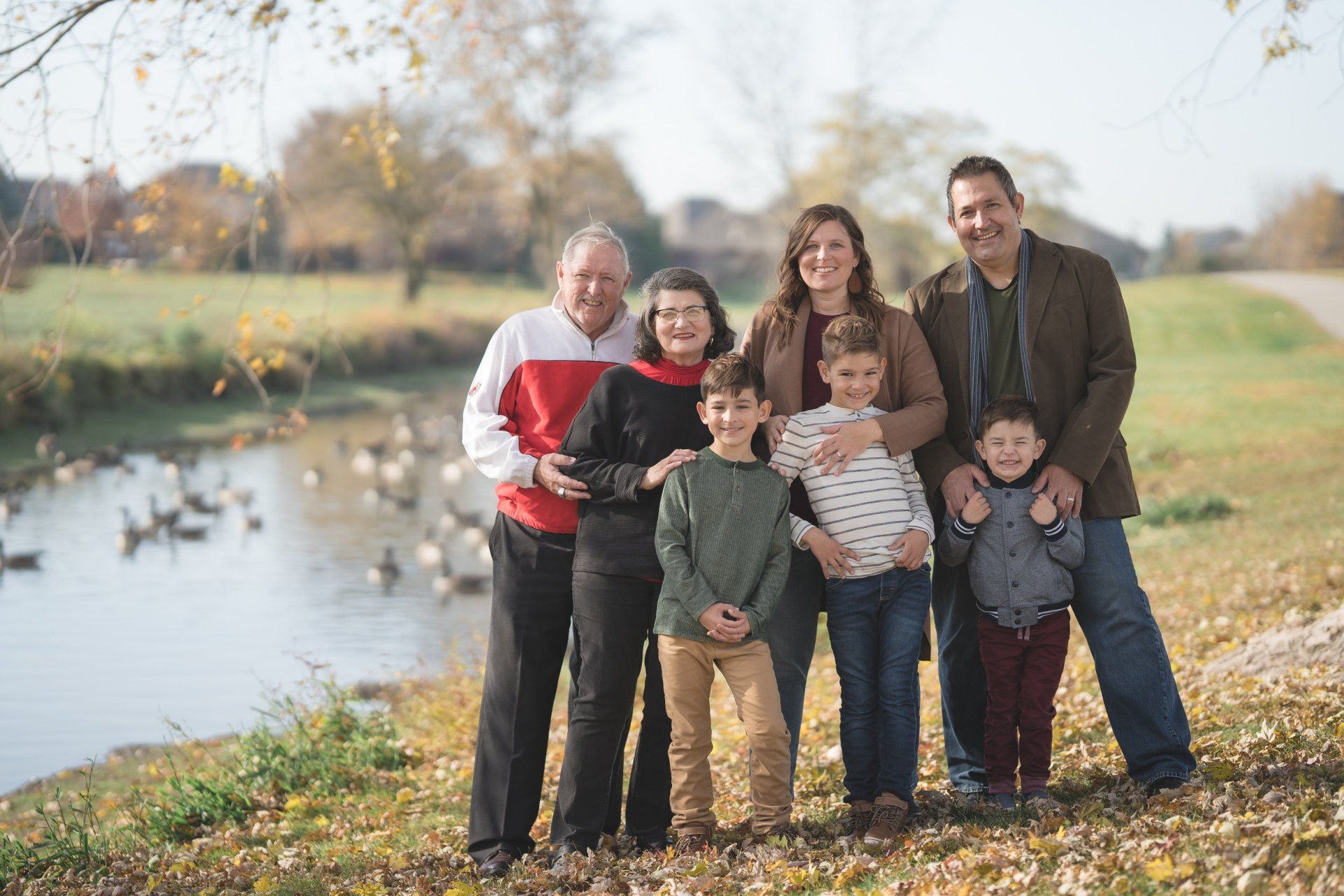 A family is posing for a picture in front of a river.