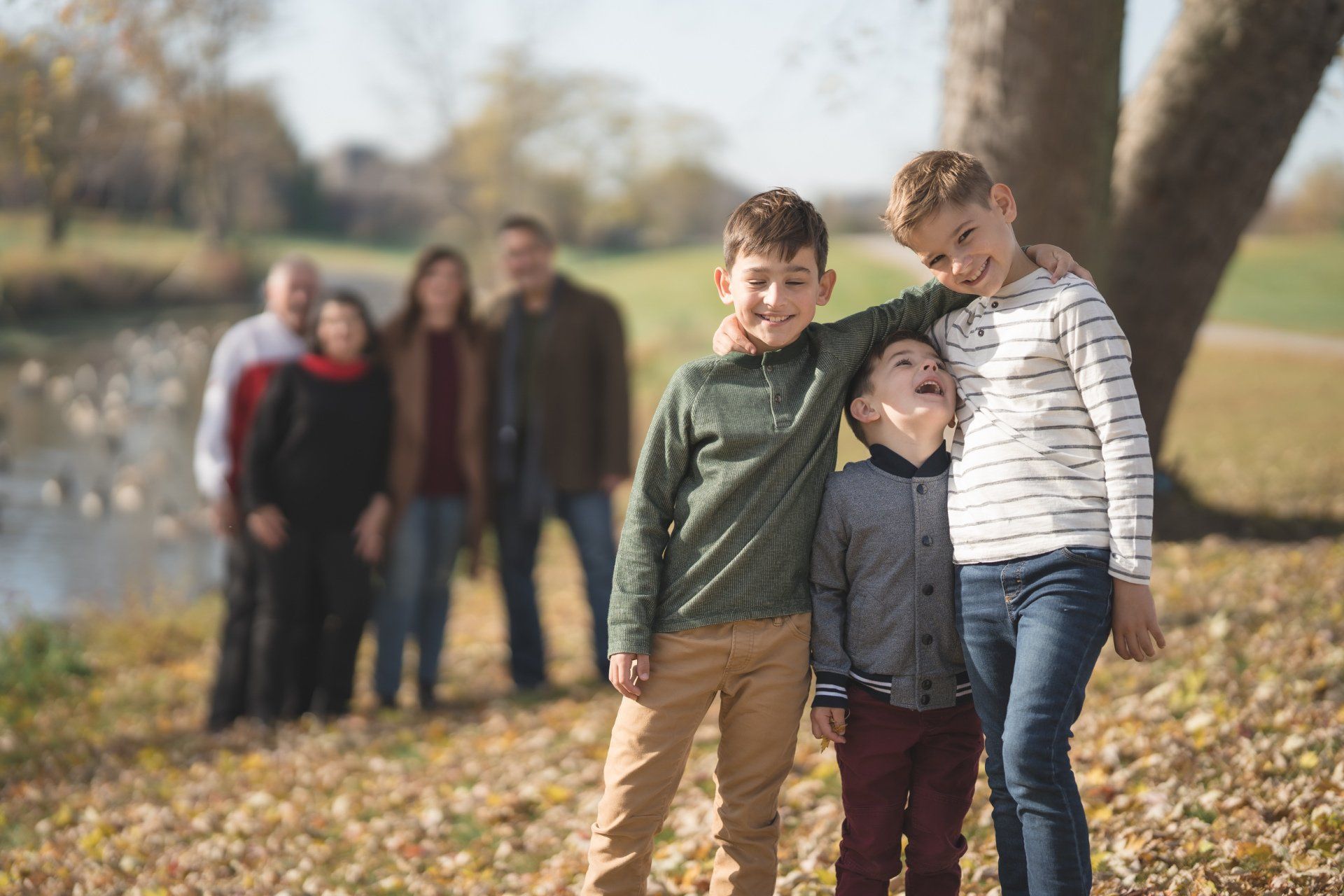 A family is posing for a picture in a park.