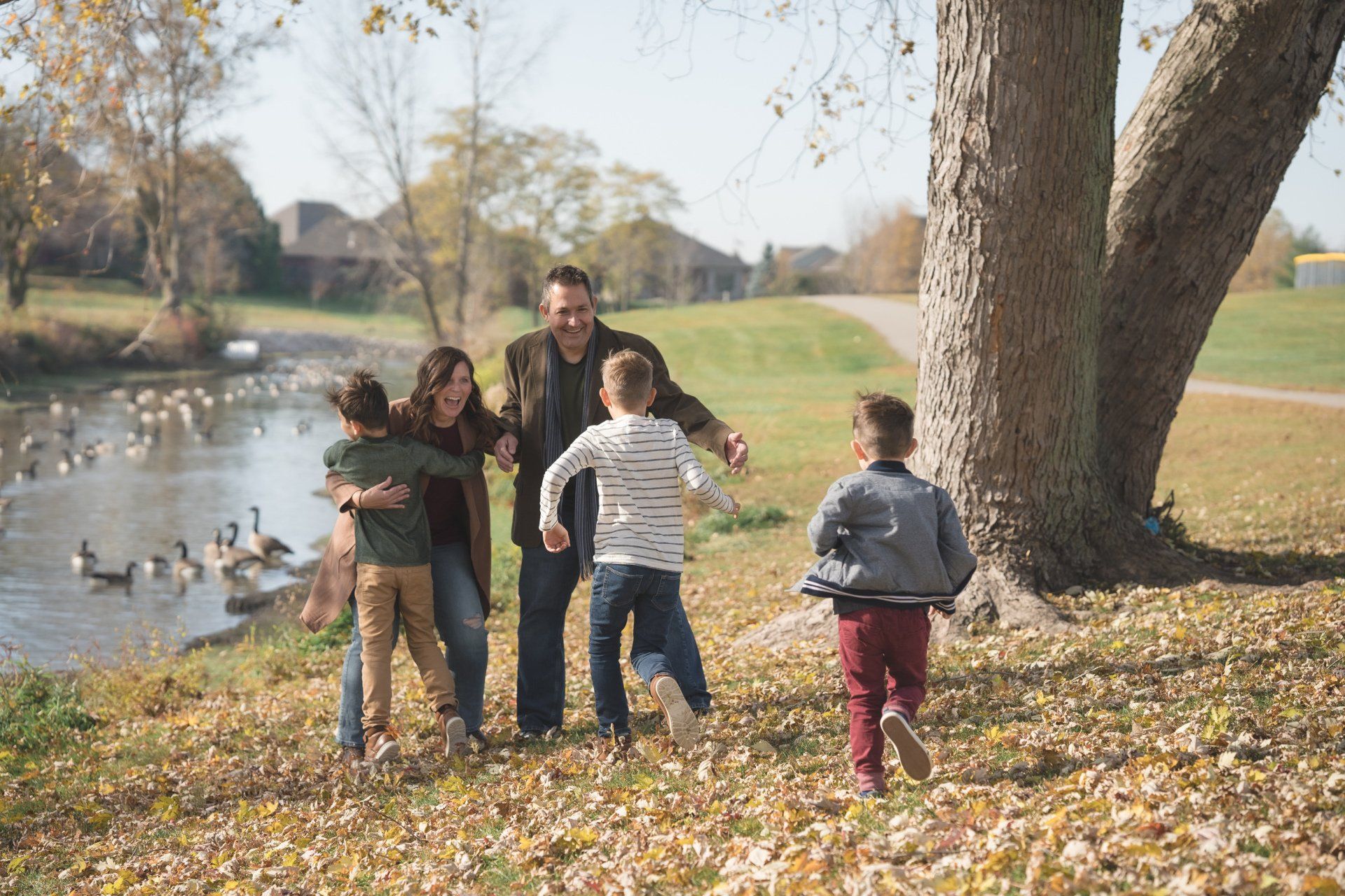 A family is walking in a park near a river.