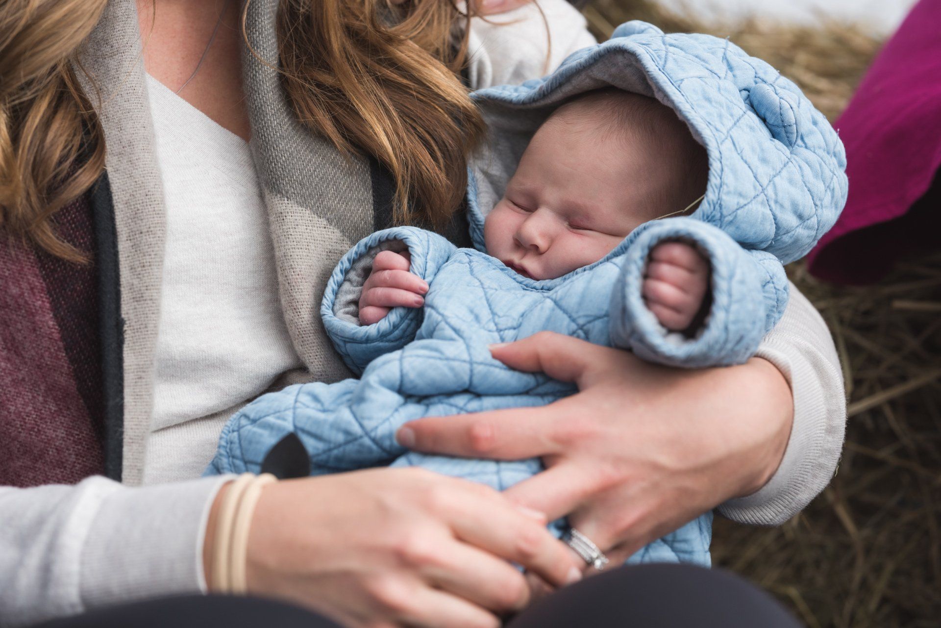 A woman is holding a sleeping baby in her arms.