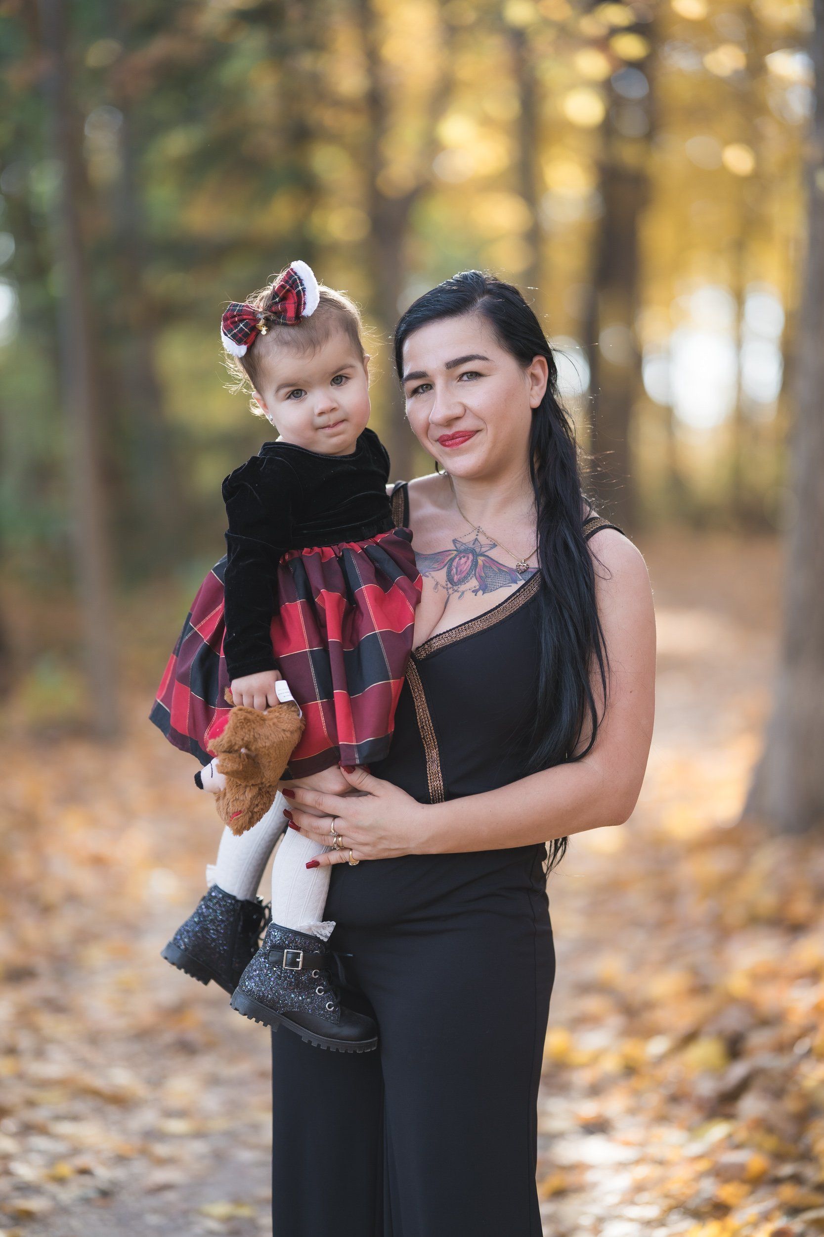 A woman is holding a little girl in her arms in a park.