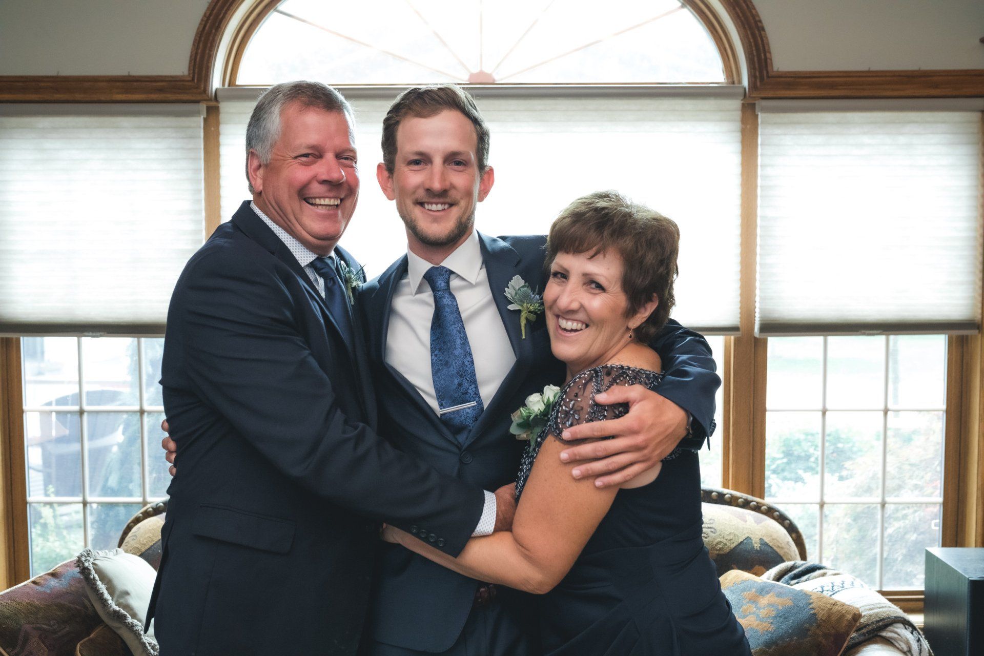 A bride and groom are posing for a picture with their parents.