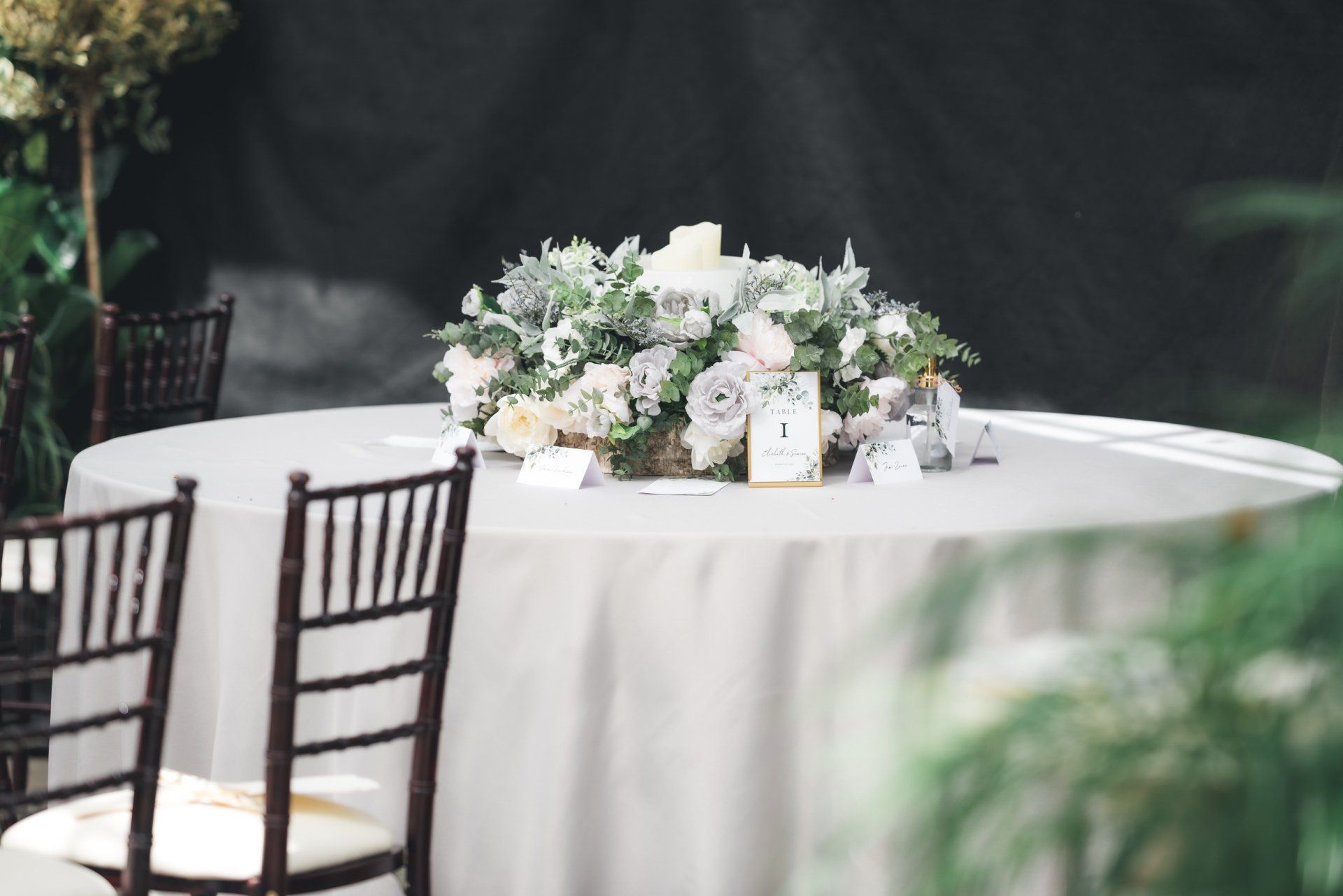 A table with a white tablecloth and a vase of flowers on it.
