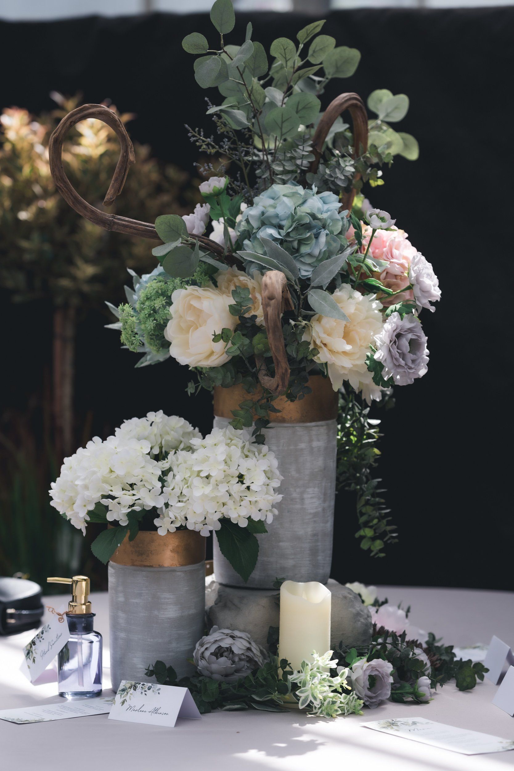 A table topped with vases filled with flowers and candles.