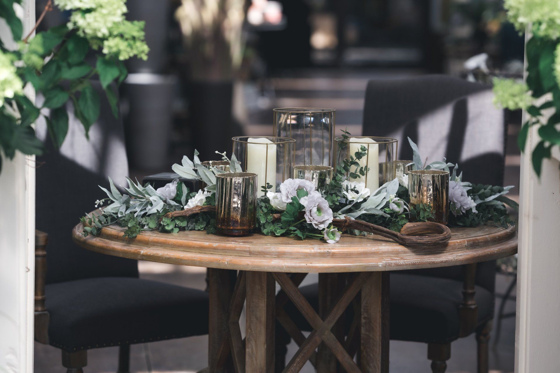 A wooden table with candles and flowers on it.
