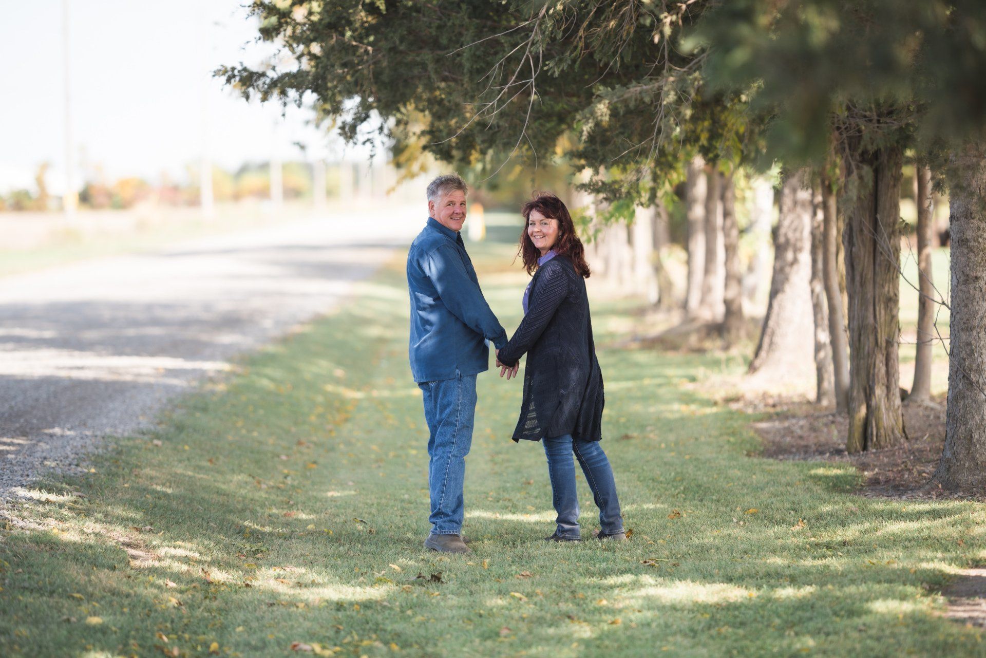 A man and a woman are holding hands in a field.