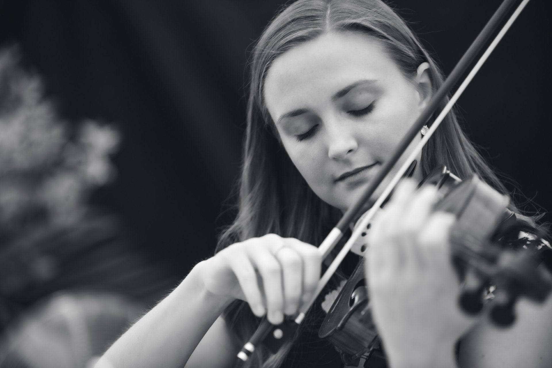 A woman is playing a violin in a black and white photo