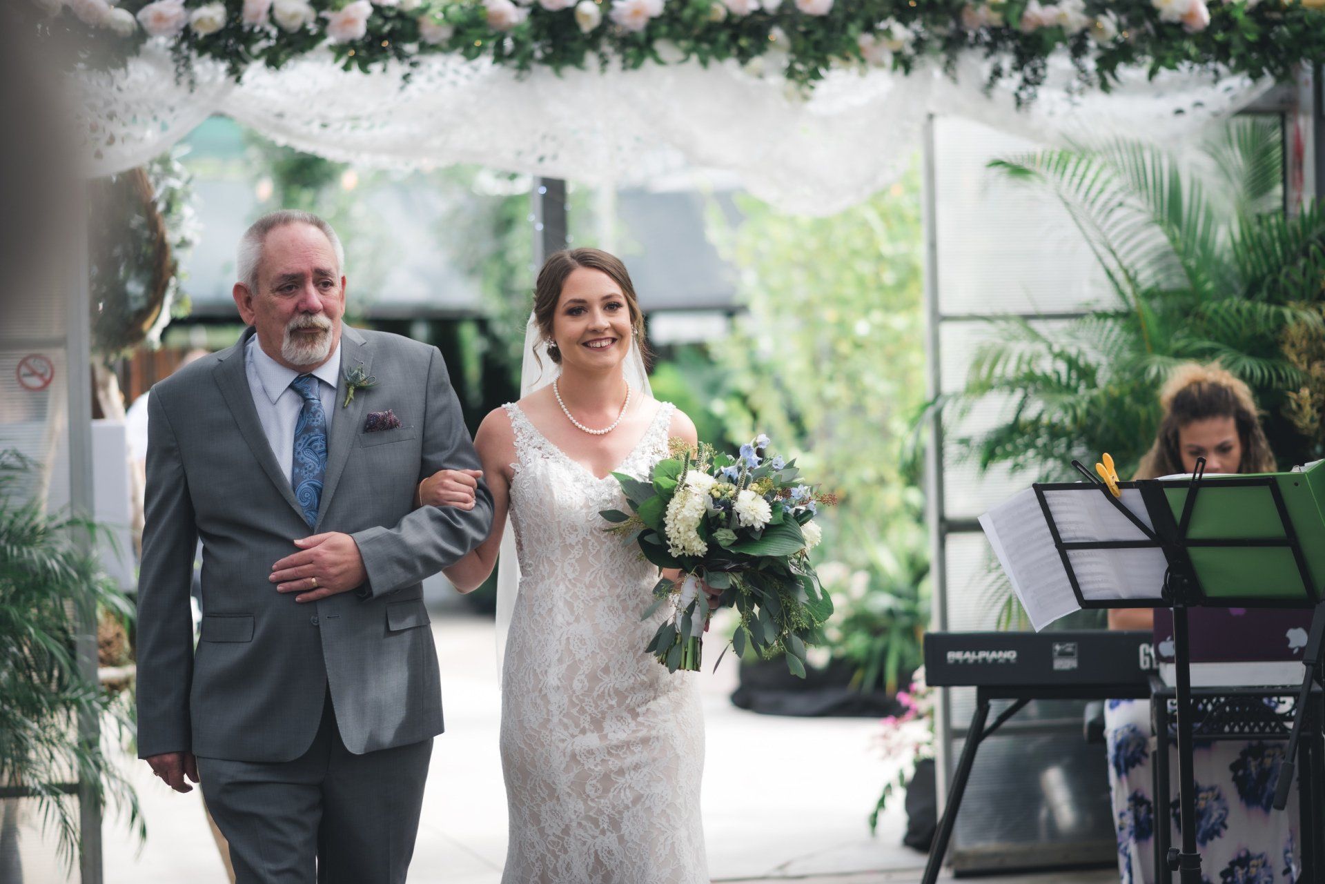 A bride is walking down the aisle with her father at her wedding.