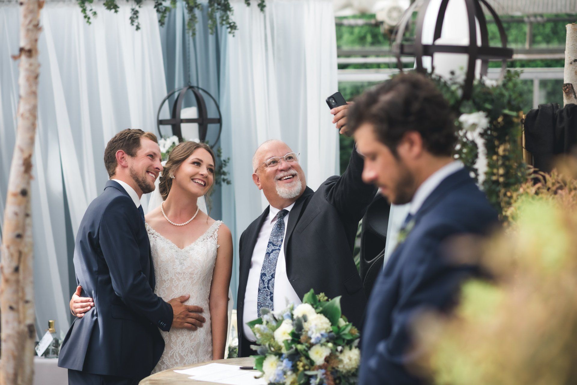 A bride and groom are posing for a picture with their parents at their wedding.