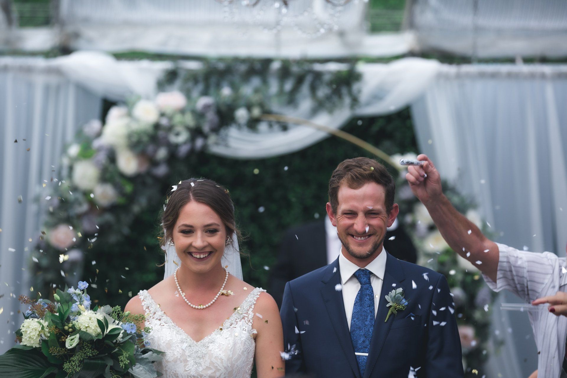 A bride and groom are walking down the aisle at their wedding.