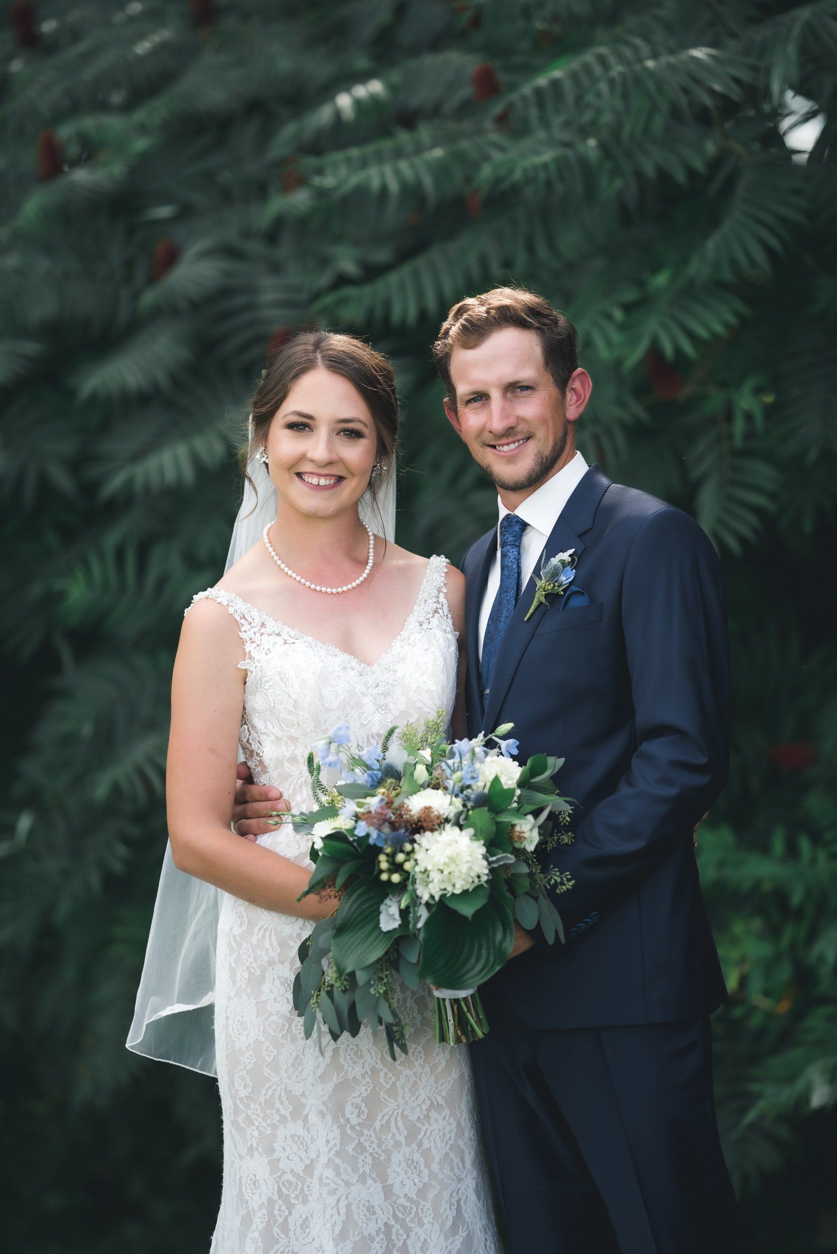 A bride and groom are posing for a picture on their wedding day.