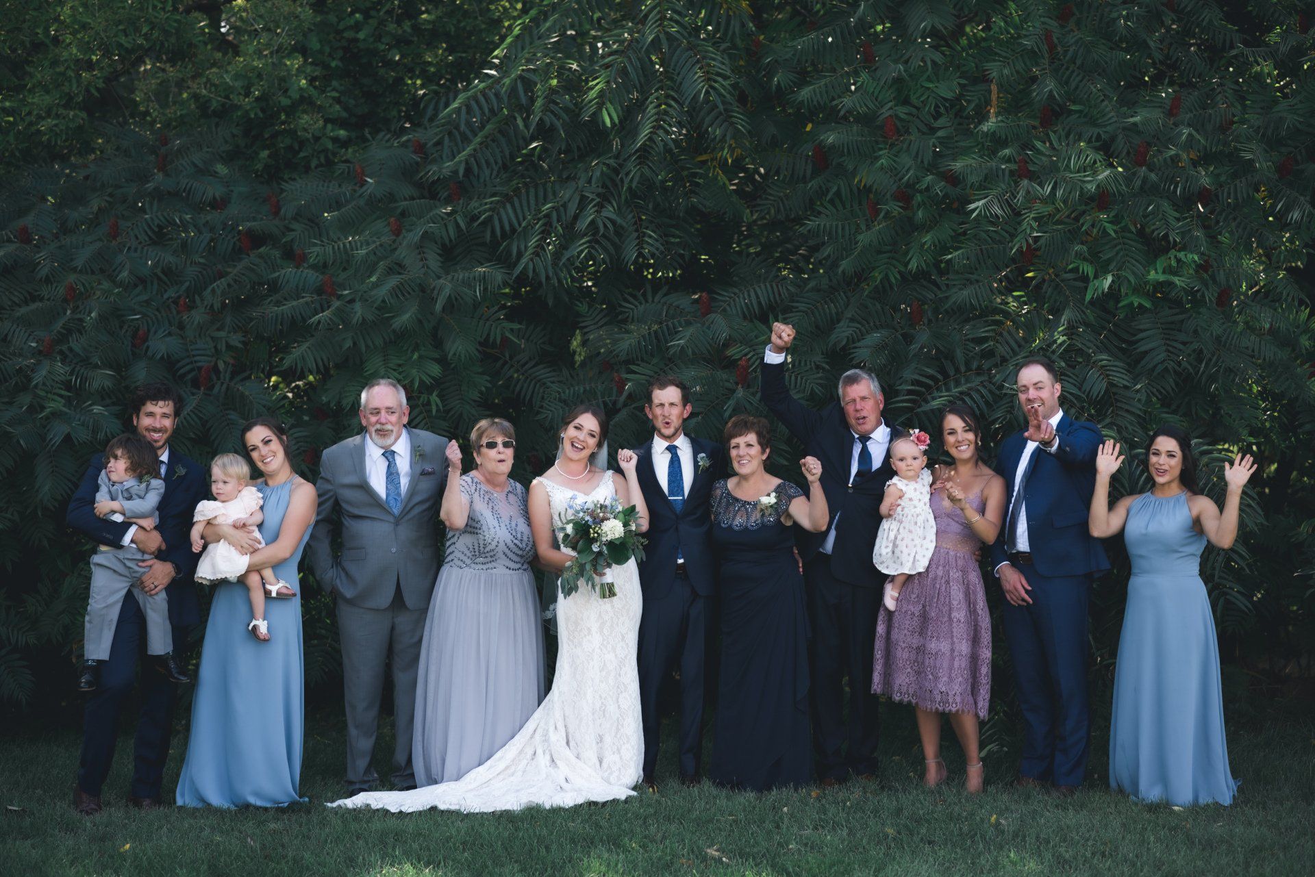A bride and groom are posing for a picture with their wedding party.