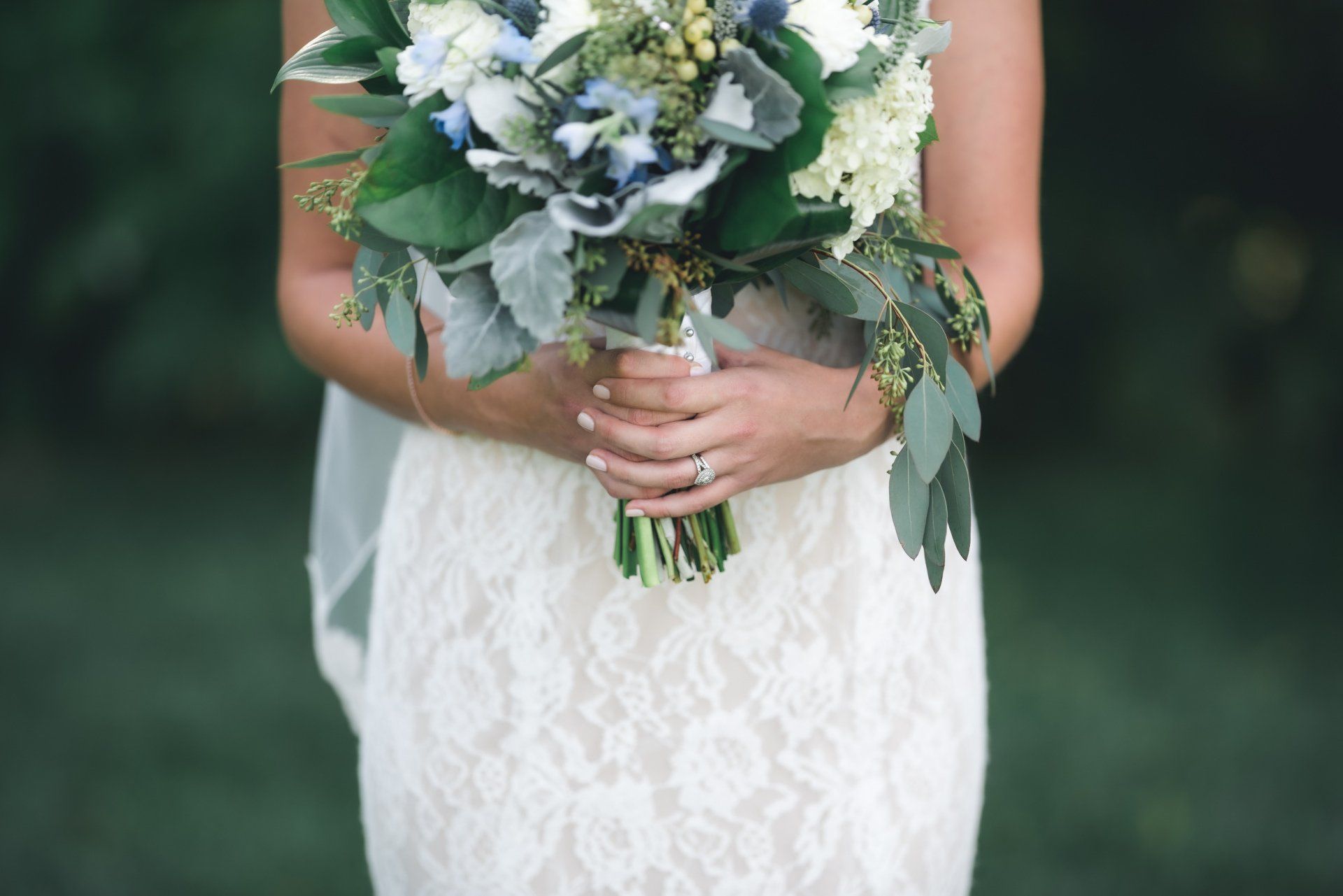 A bride in a white dress is holding a bouquet of flowers.