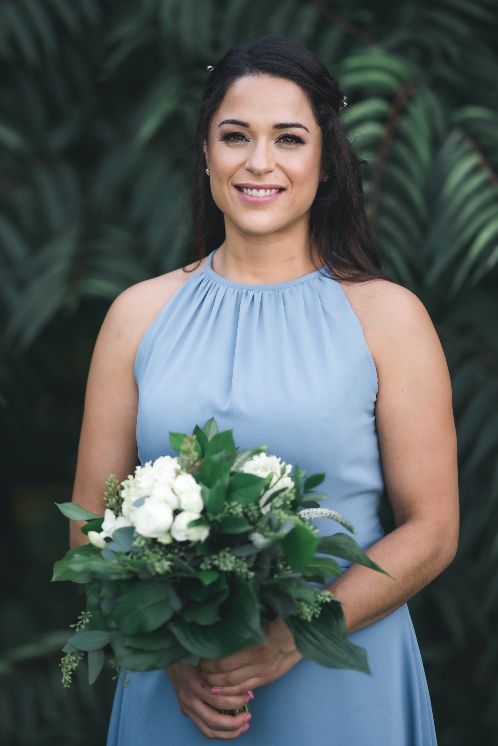 A woman in a blue dress is holding a bouquet of flowers.