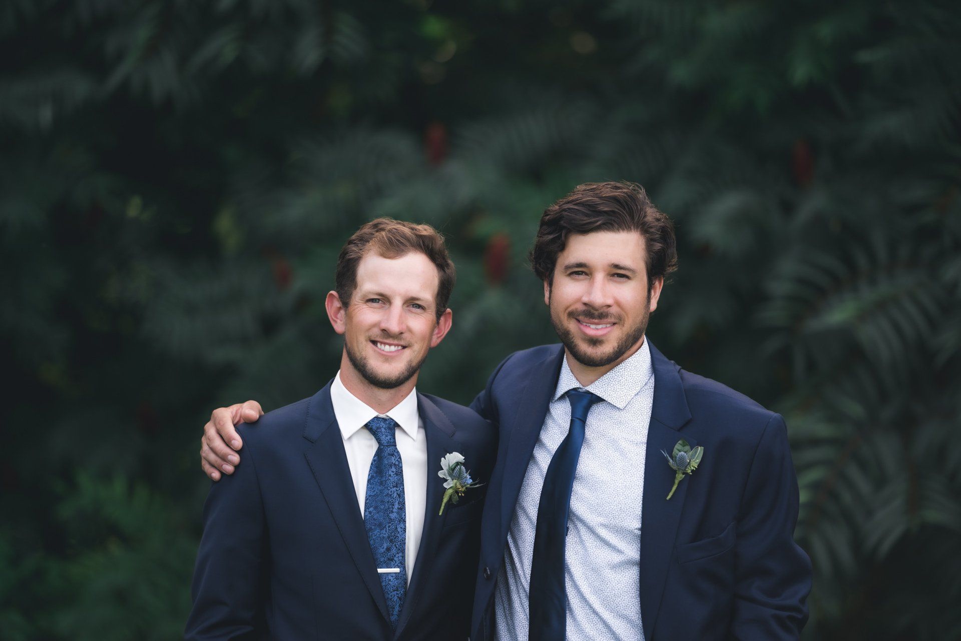 Two men in suits and ties are posing for a picture.