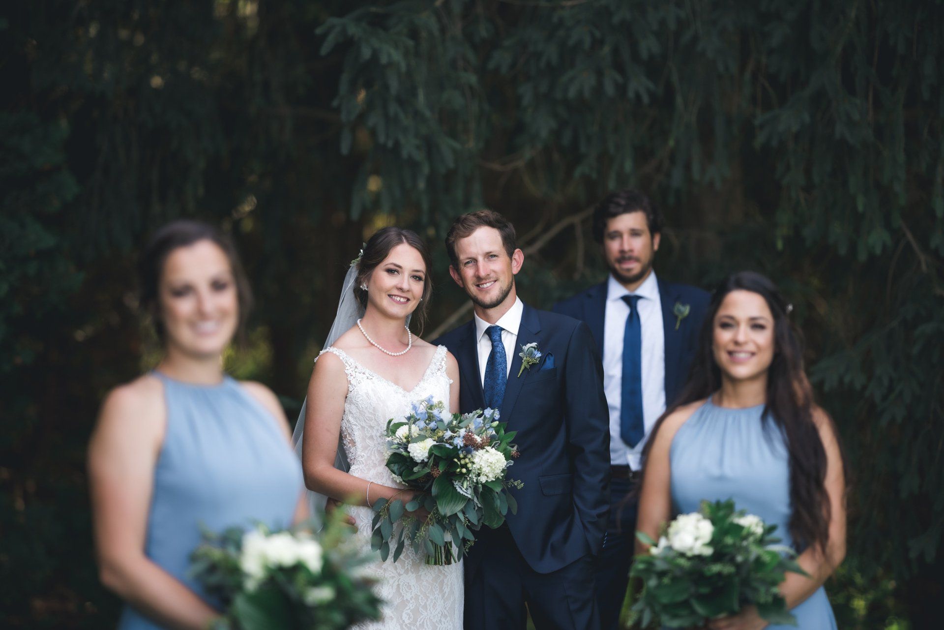 A bride and groom are posing for a picture with their wedding party.