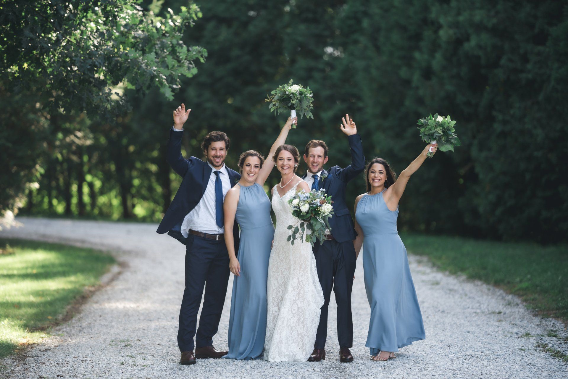 A bride and groom are posing for a picture with their bridesmaids.